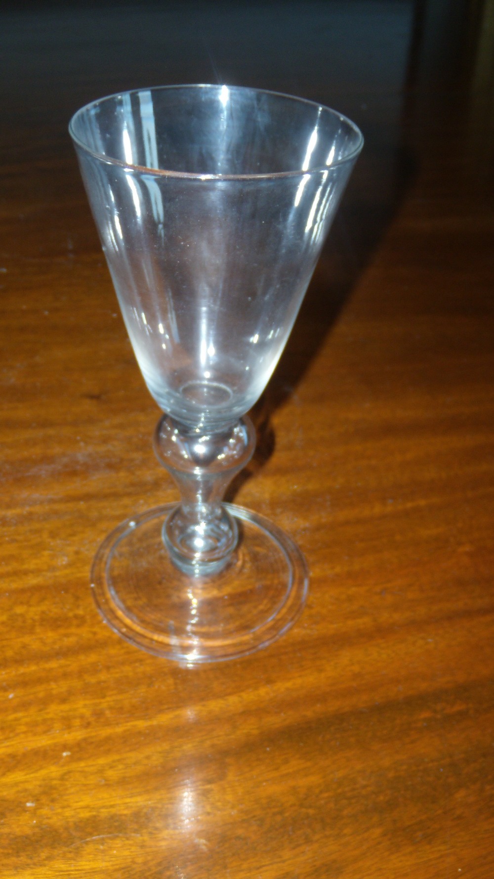 A mid 18th century soda glass wine, the conical bowl on hollow baluster stem and folded foot,