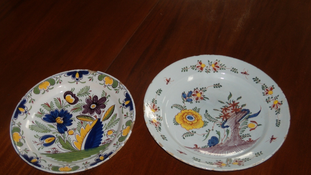 Two mid 18th century Delft polychrome dishes, one painted with a yellow flower growing by a