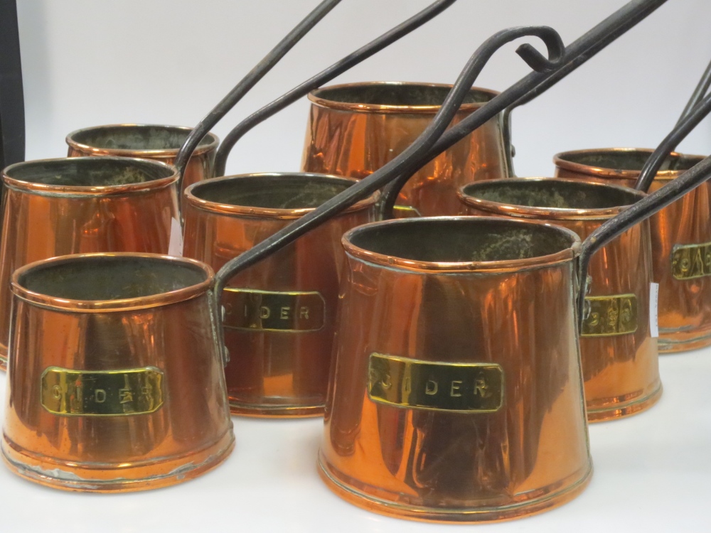 A set of eight copper `cider` measures