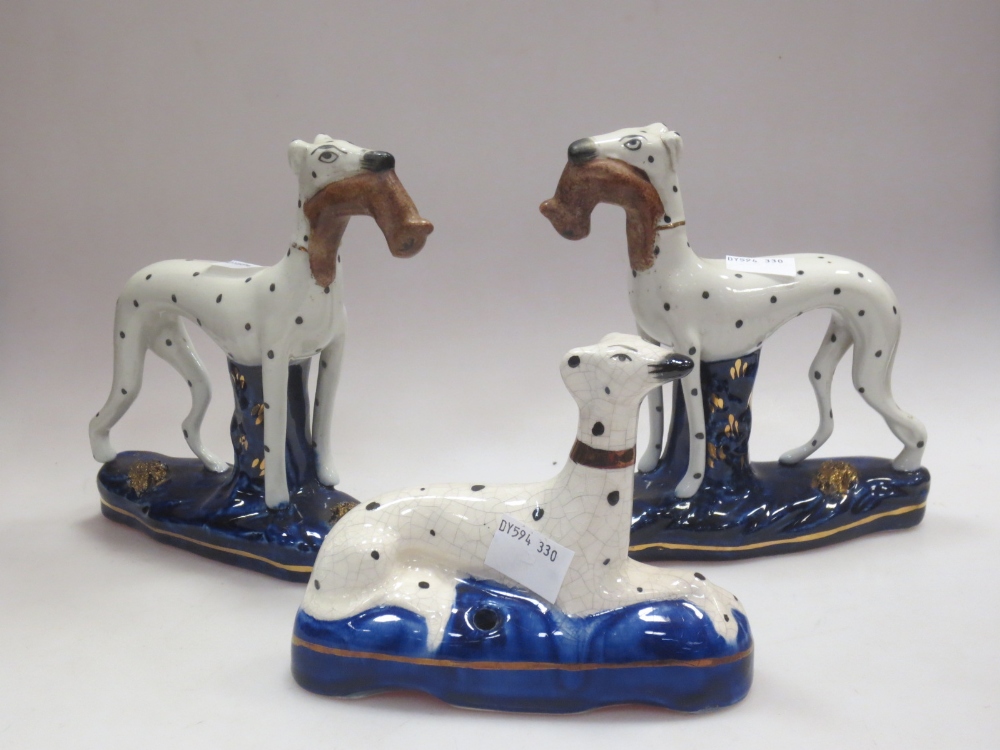 A pair of Staffordshire pottery Dalmatians and another