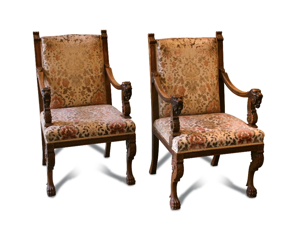 A pair of 17th century style Continental walnut framed open armchairs, the open arms carved with