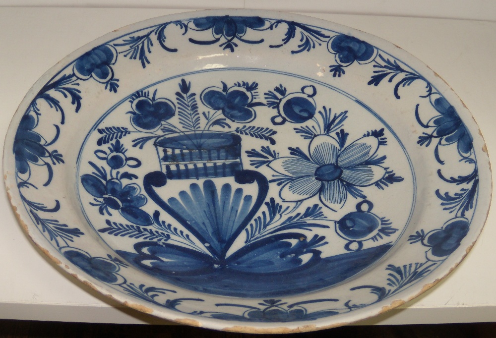 An 18th century Delft blue and white dish, possibly Bristol, painted with a large vase of two
