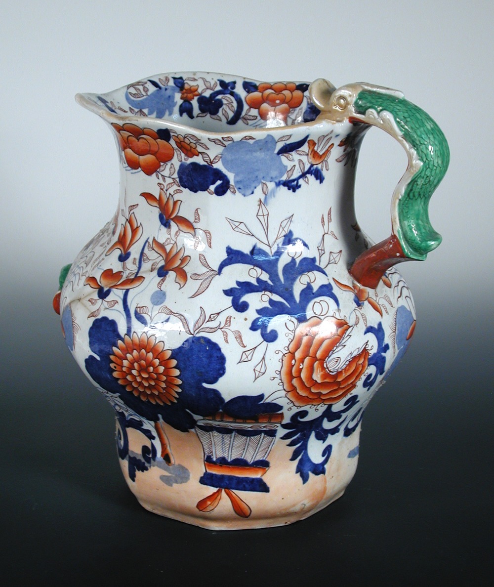 An early 19th century Mason`s ironstone jug, the serpent handled facetted baluster shape printed