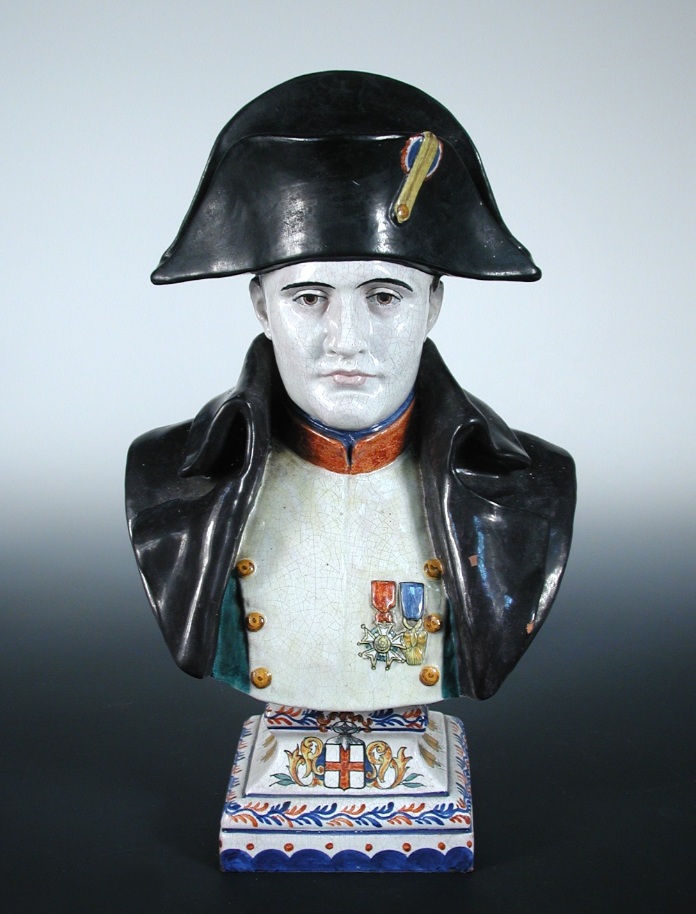 A late 19th/early 20th century French faience bust of Napoleon dressed in usual military attire and