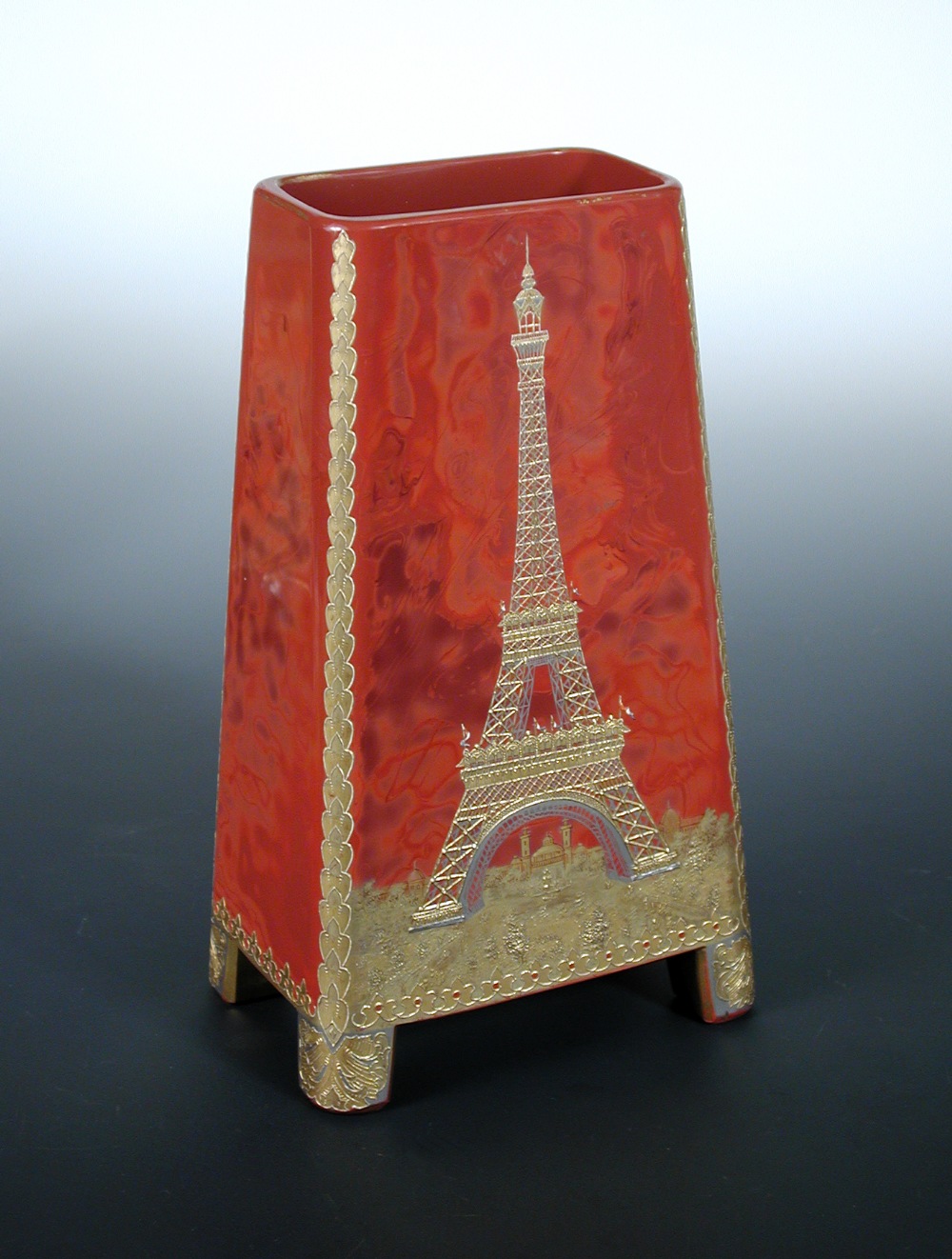 An Art Deco `realgar` glass vase, decorated in gilt with the Eiffel Tower to one side, and a hot air