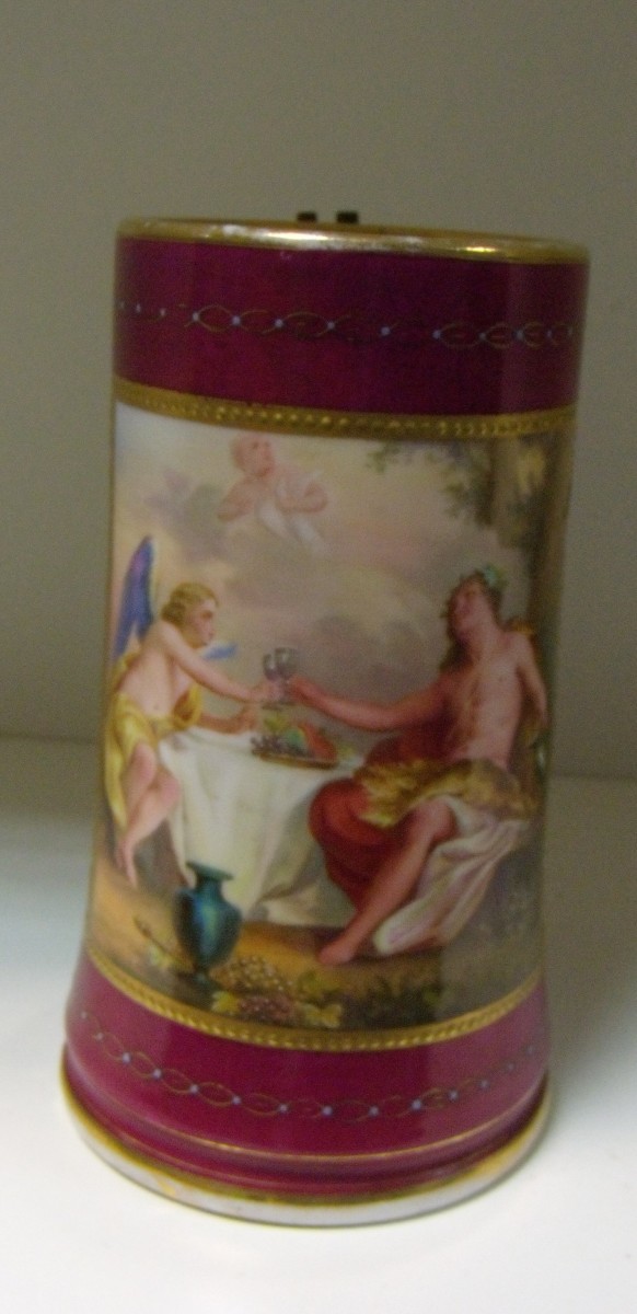 A late 19th century Vienna mug, painted with a gilt framed reserve of Bacchus seated at a table