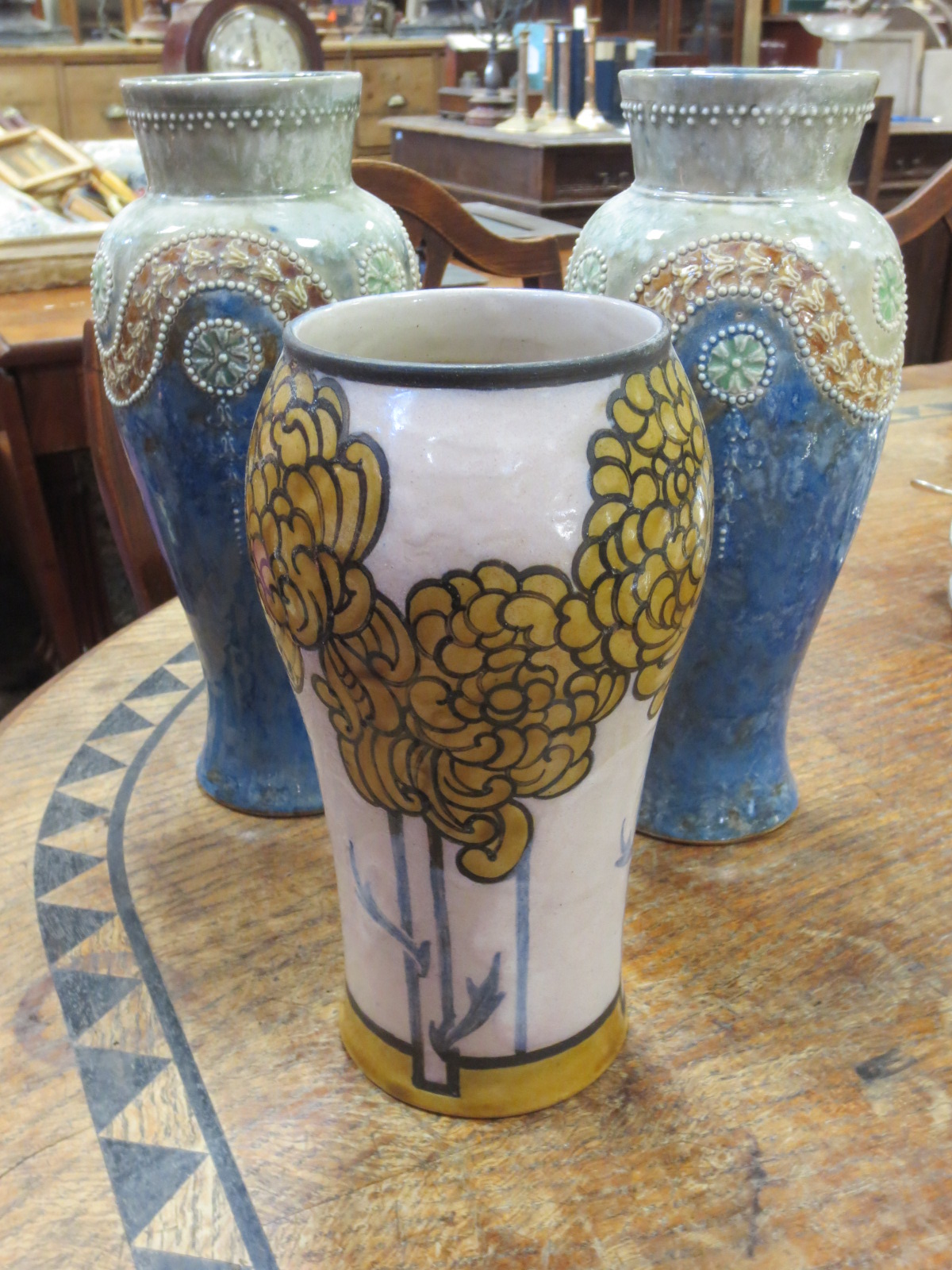 A pair of Doulton stone ware vases and another with yellow daisies