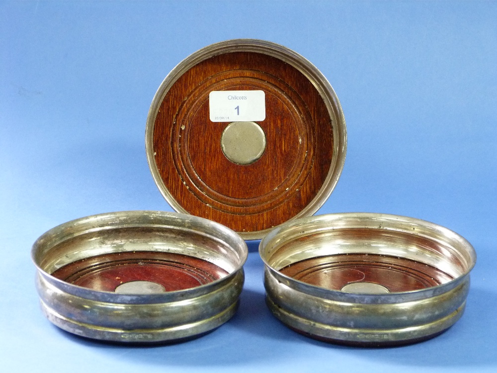 A set of three silver Wine Coasters, hallmarked Birmingham, 2005, each of circular form with turned