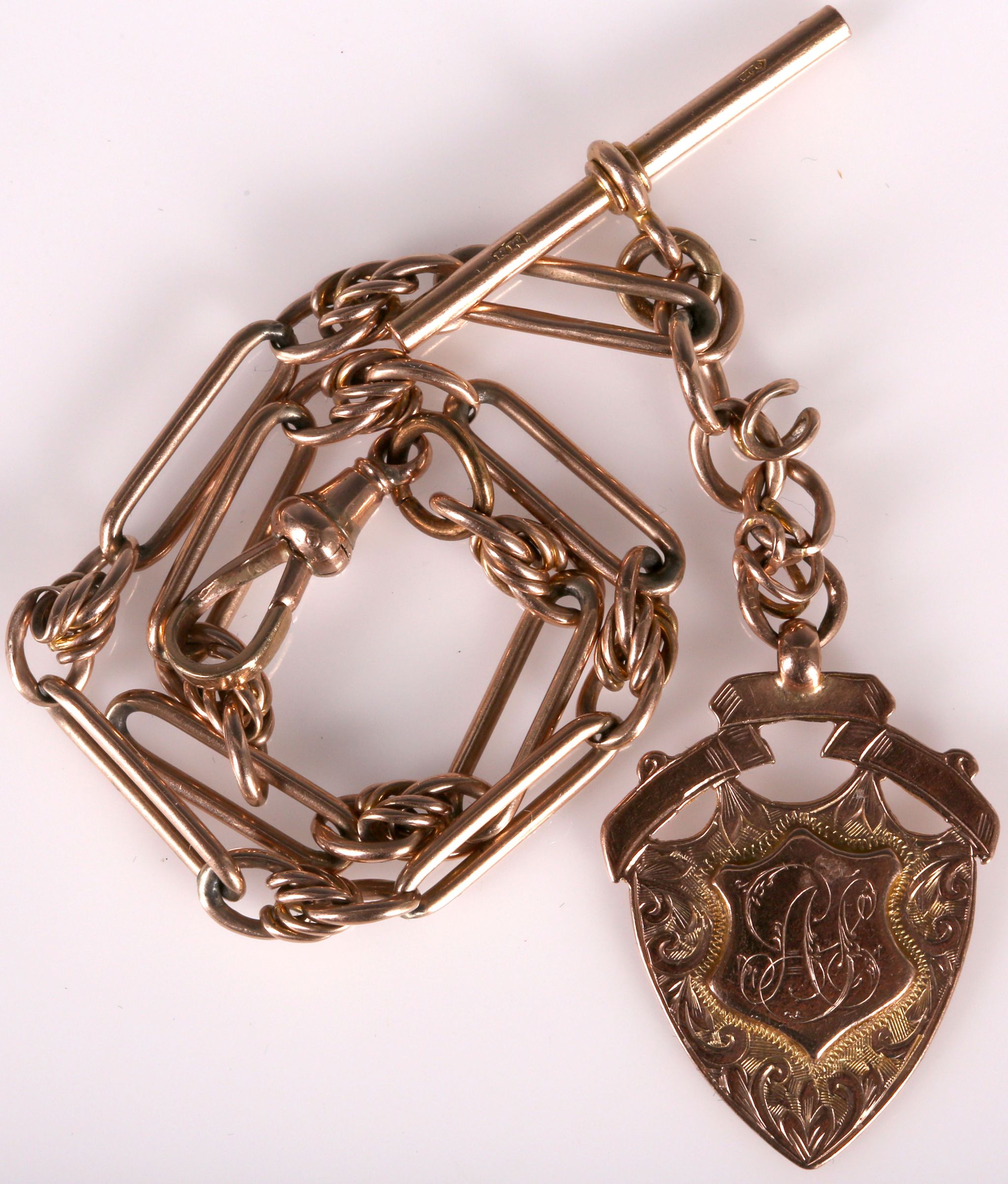 An antique 9ct rose gold Albert chain, the fancy jailers link hung with a 9ct shield charm.