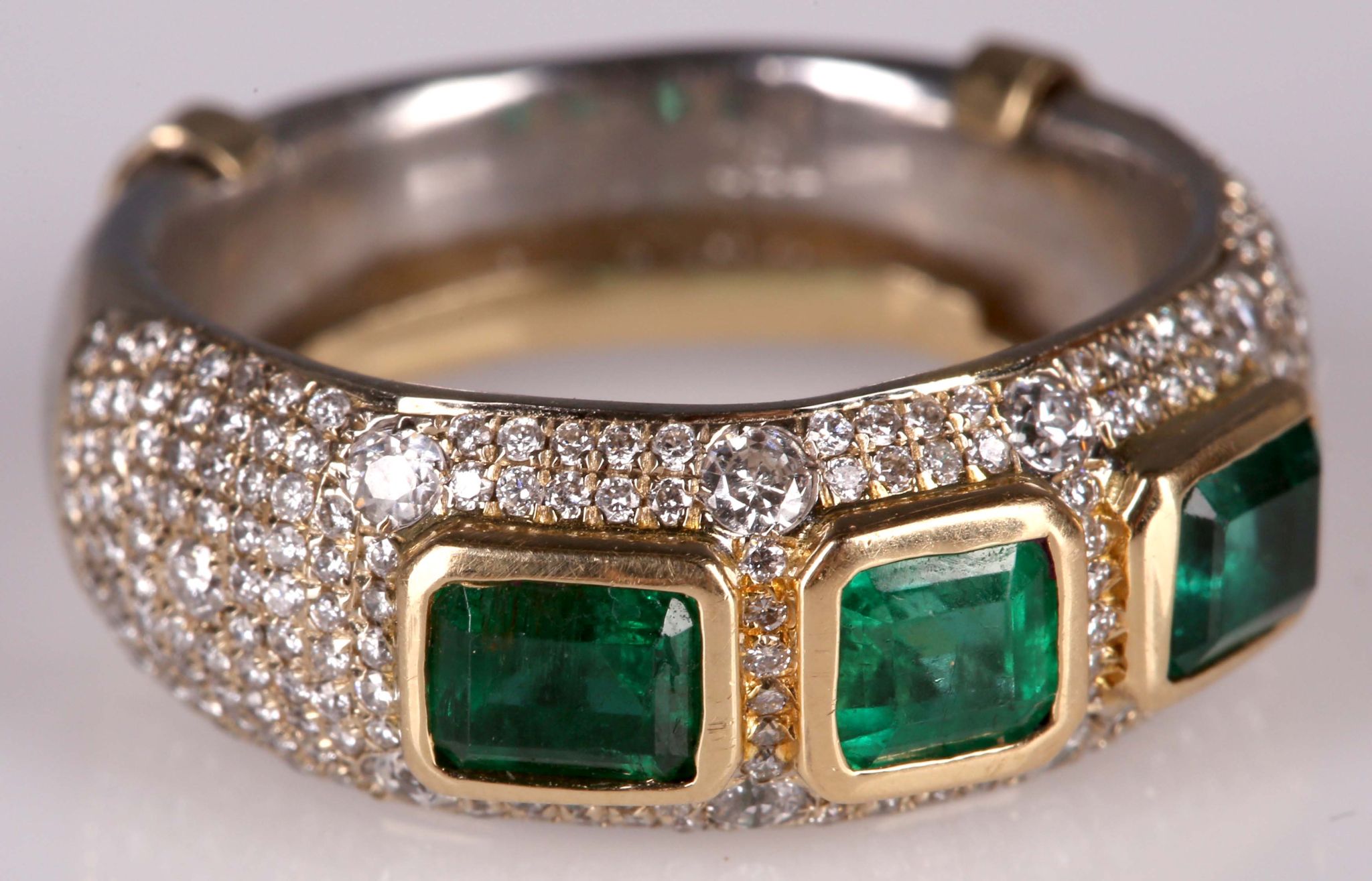 A fine 18ct gold emerald and pave diamond set ring.