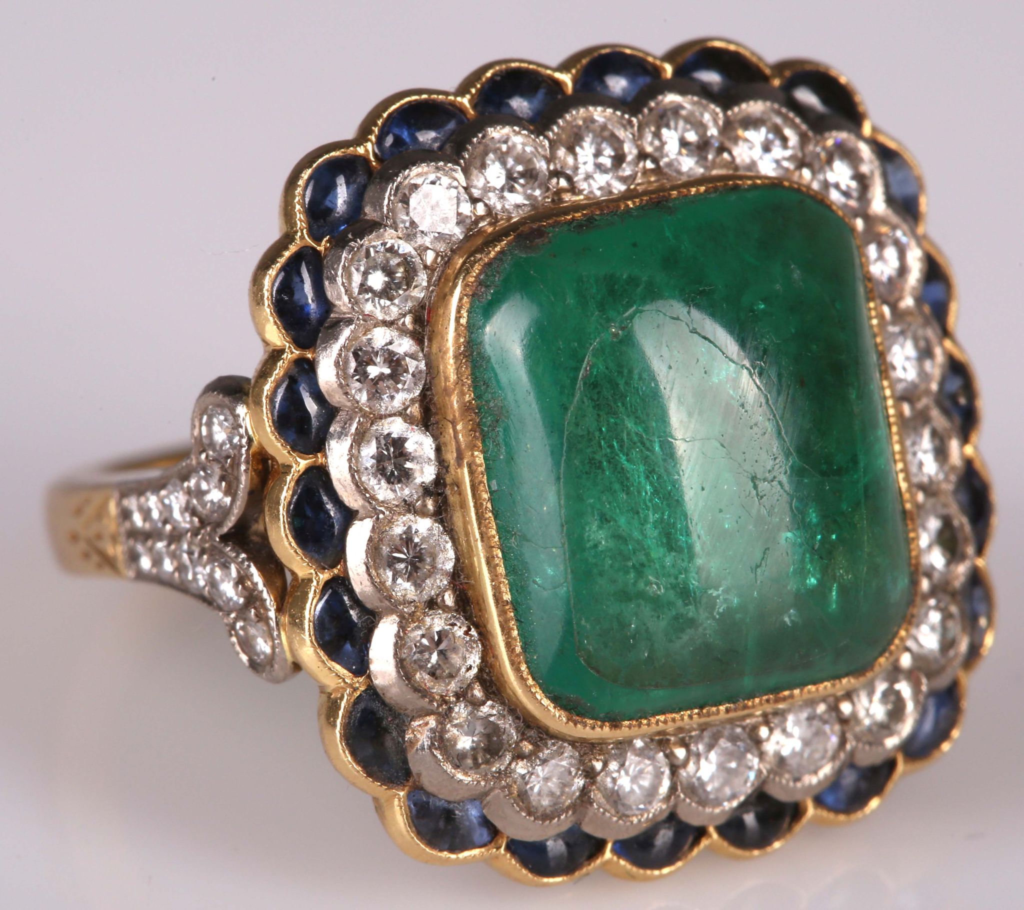 An impressive 18ct gold, cabouchon emerald, diamond and sapphire set dress ring, the large emerald