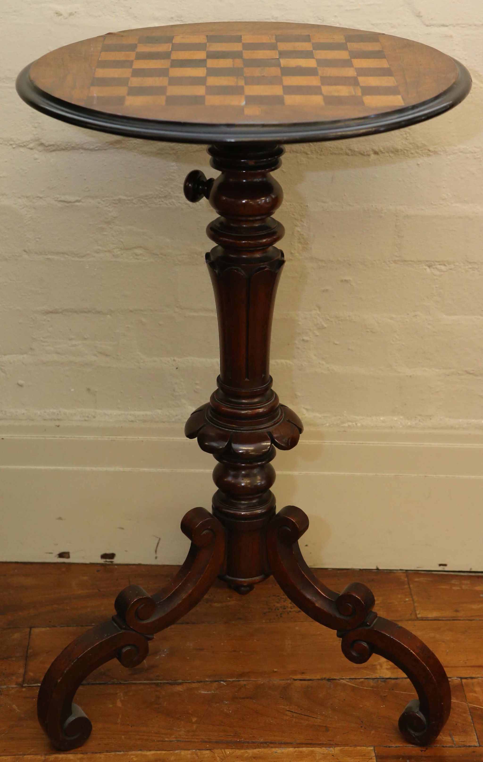 A Victorian rise and fall games table, in mahogany, with rosewood inlay and raised on turned and