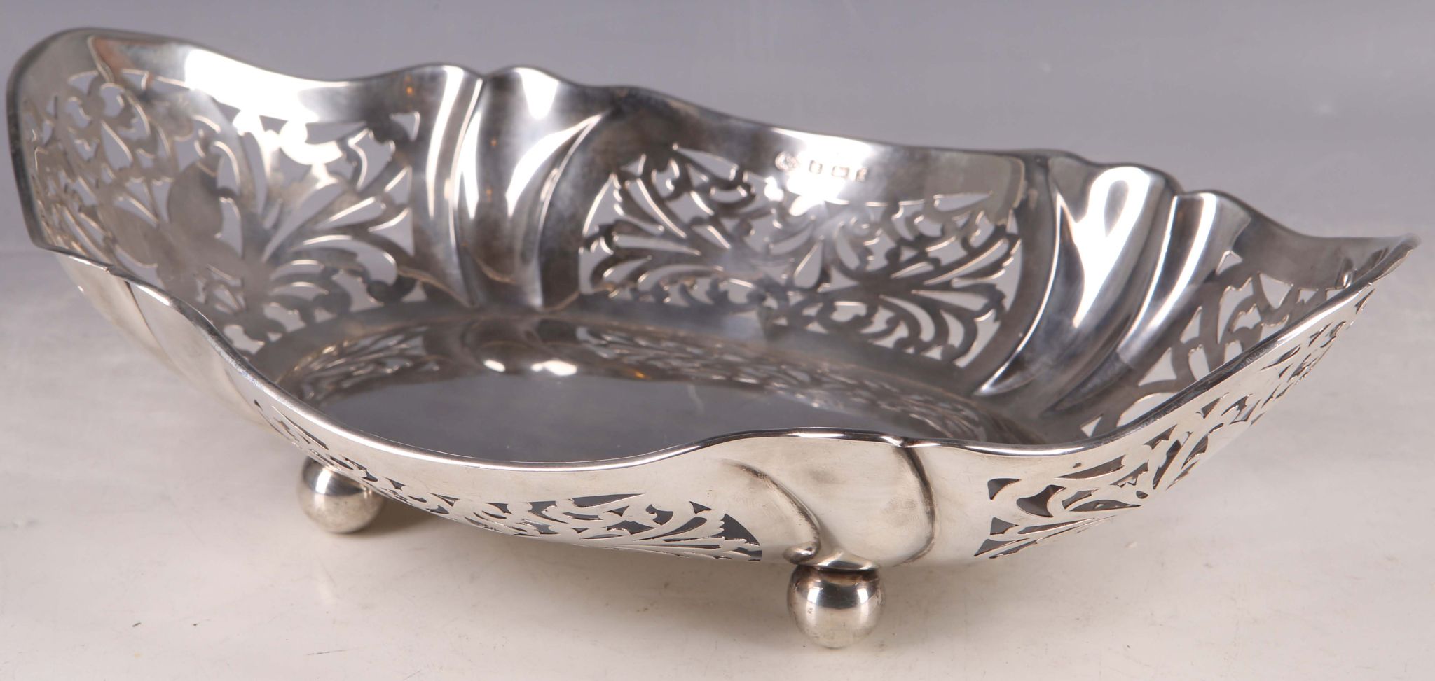 An early 20th Century silver cake / biscuit basket, pierced foliate and butterfly decoration, ball