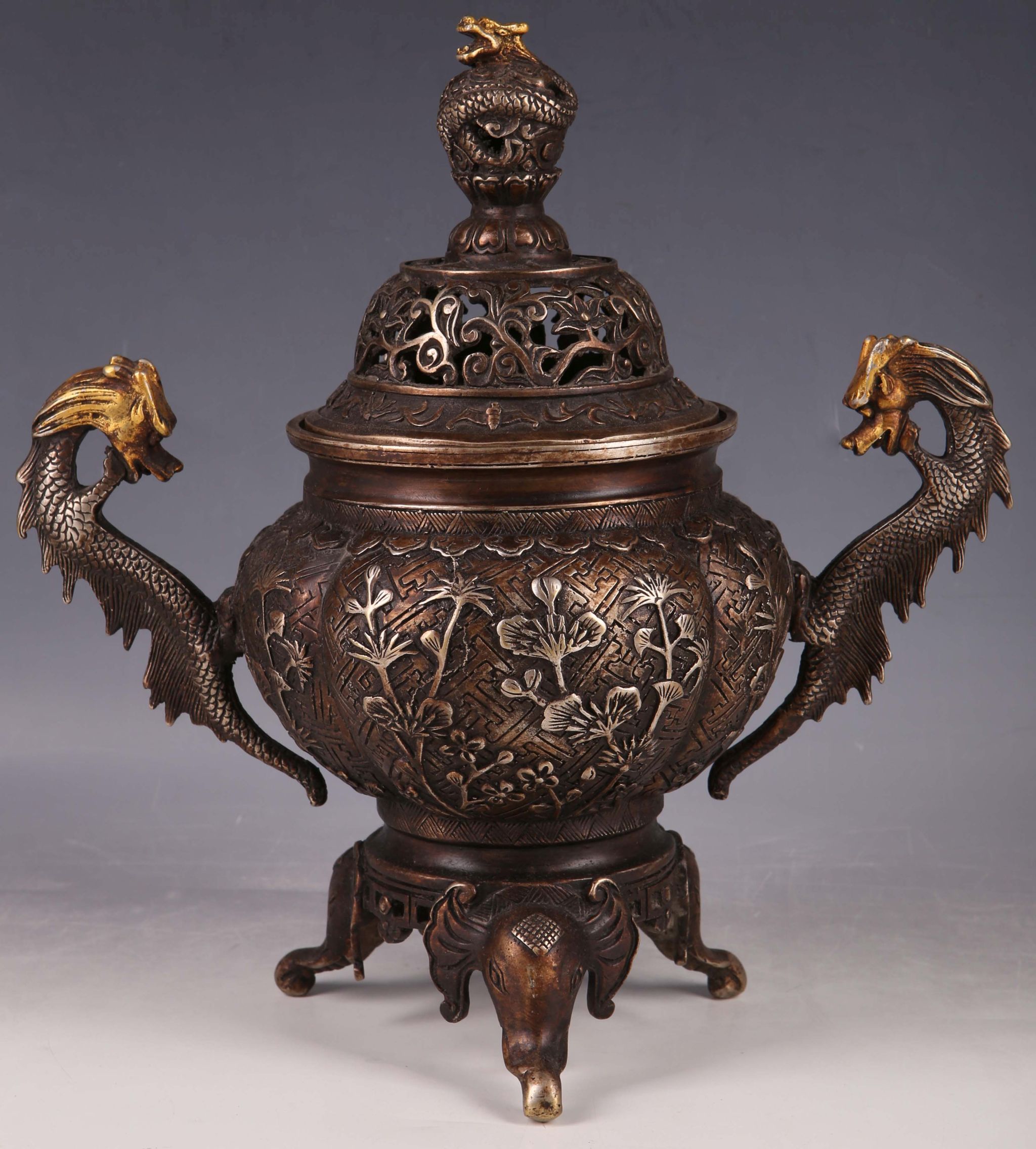 A Chinese-Tibetan Koro incense burner, gilded dragon finial, pierced floral cover with bats, twin