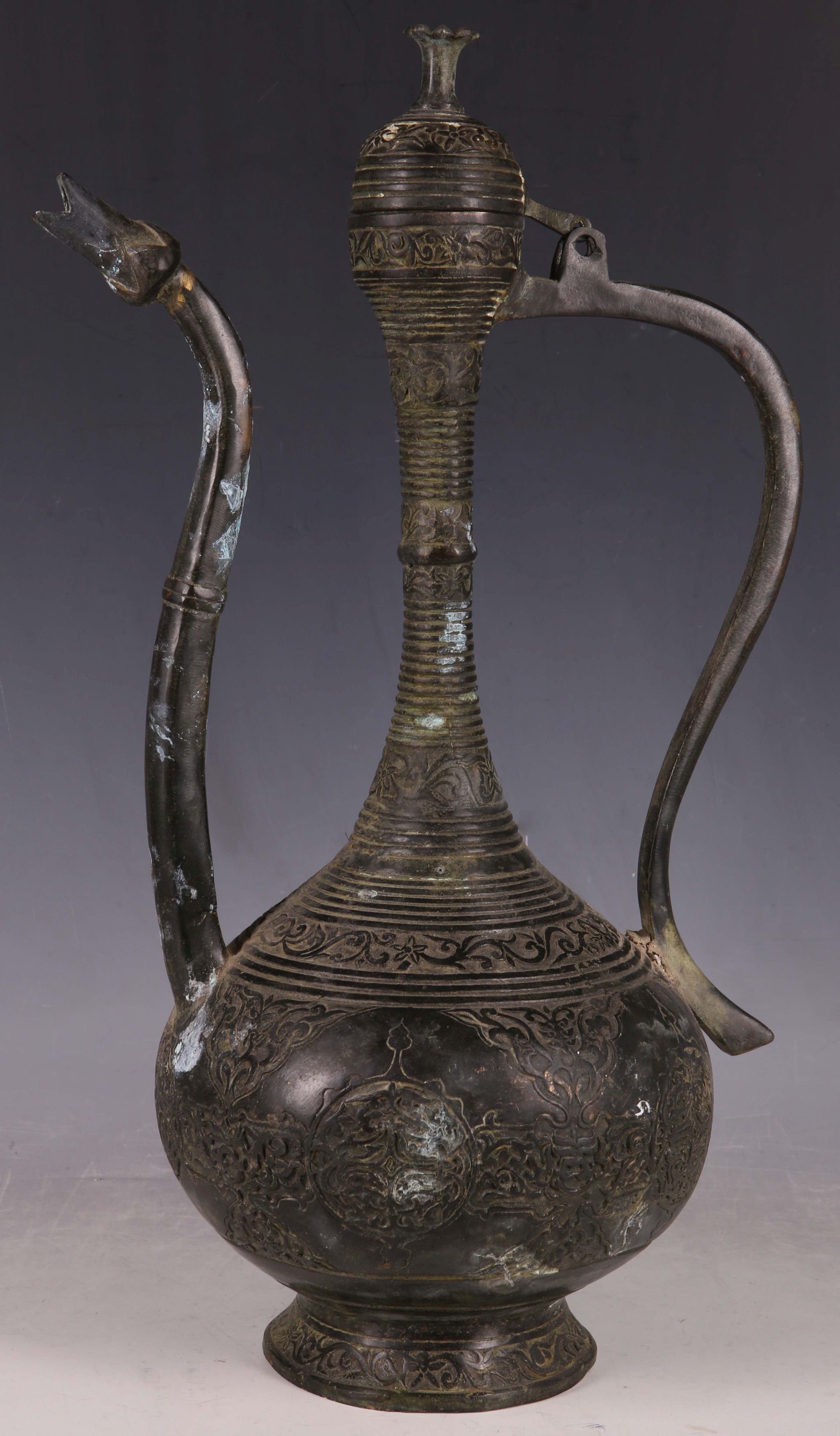 An archaic form Islamic style bronze ewer cast with intricate design, the hinged lid and floral form