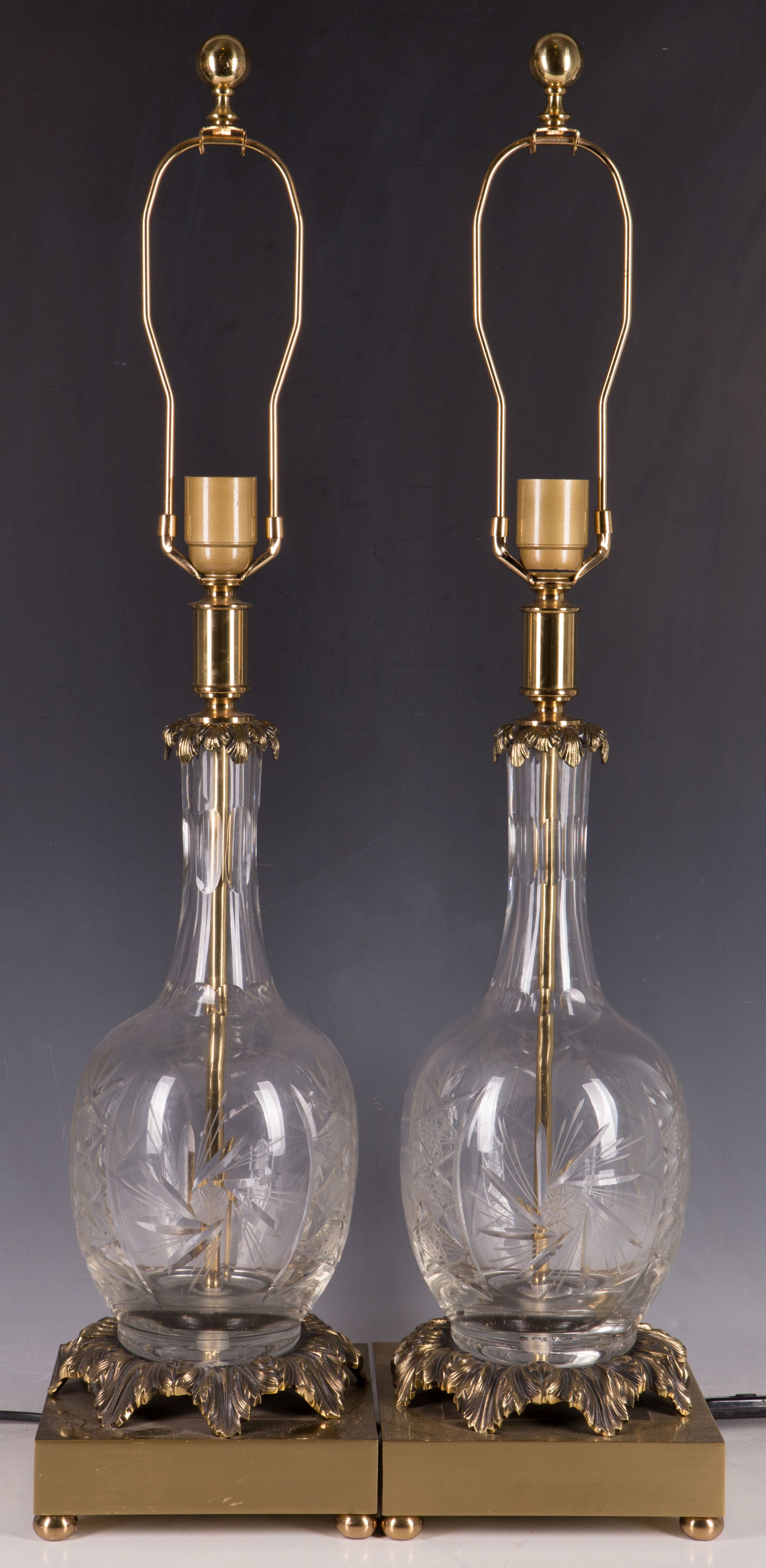 A pair of contemporary table lamps, brass leaf collar, etched and cut glass bottle body, further