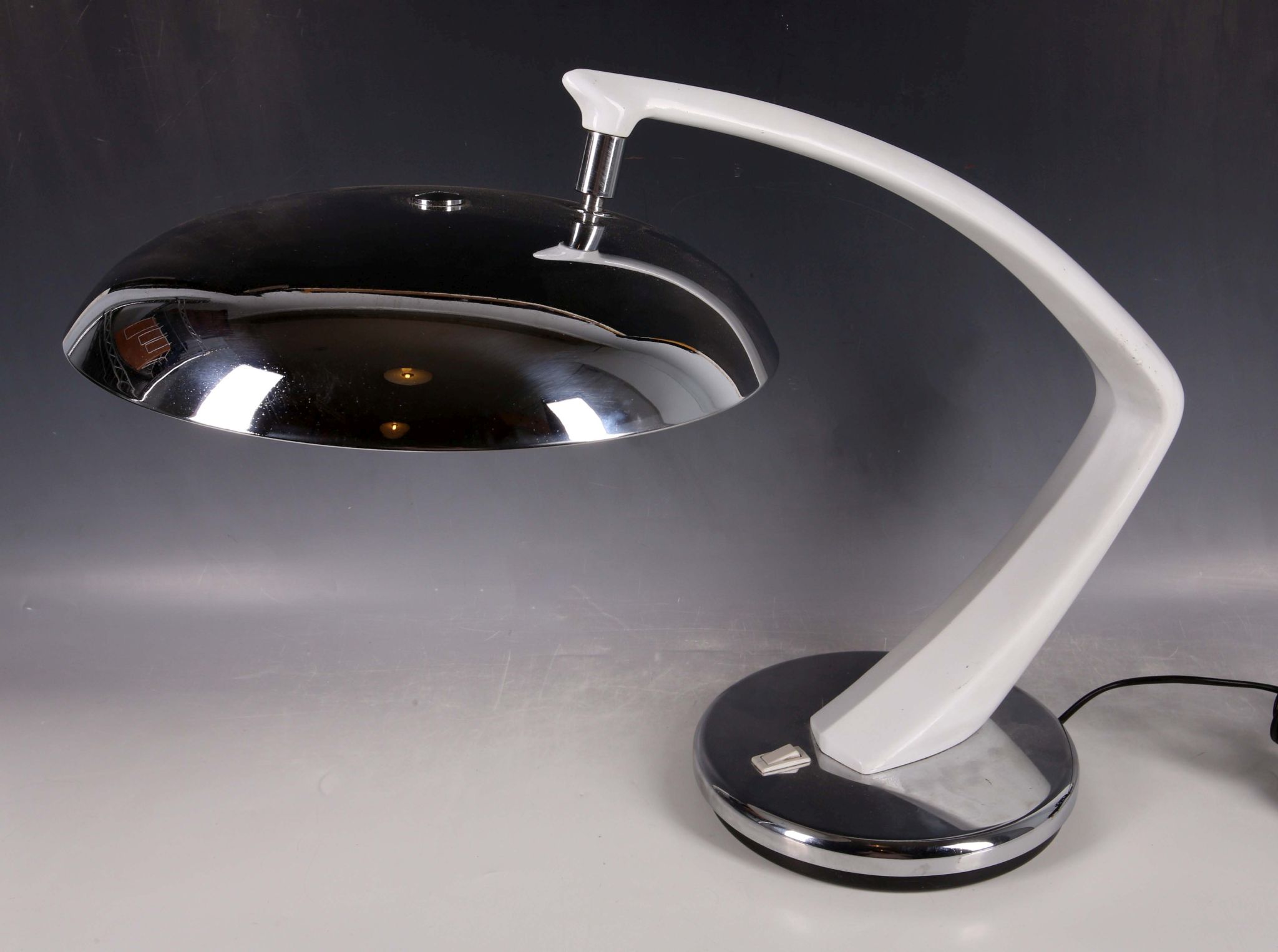 A 1960s Fase lamp, polished steel shade with white acrylic diffuser, joined to a circular polished