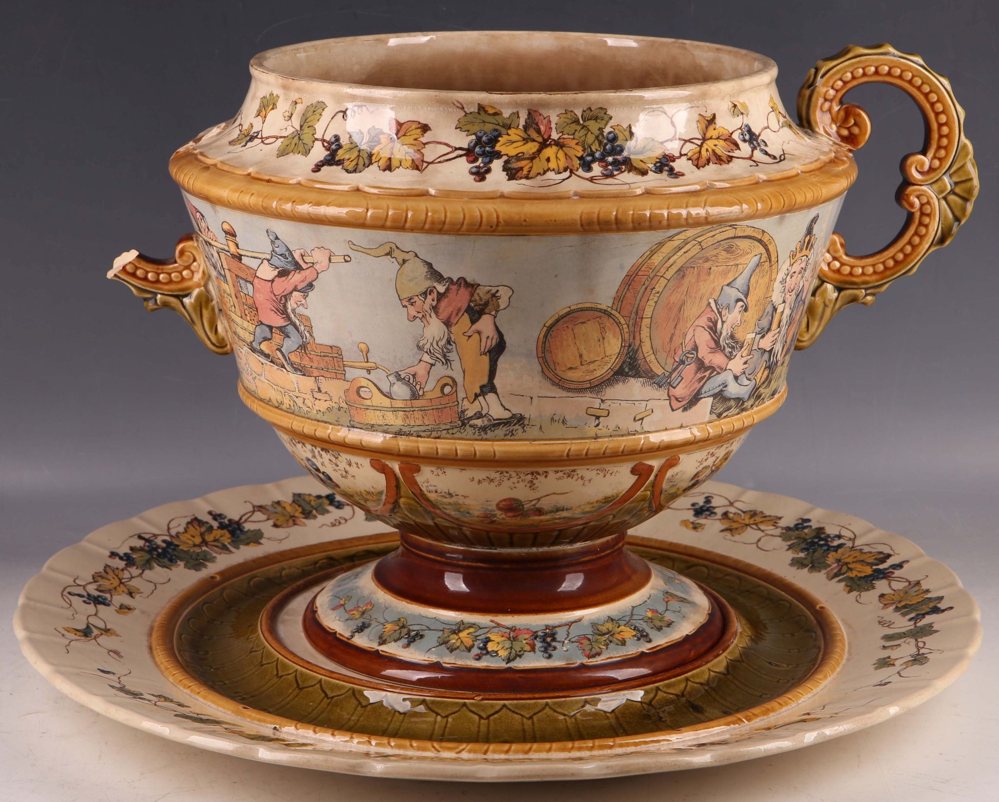 A late 19th Century Mettlach factory pottery twin-handled bowl on stand, with amusing group of