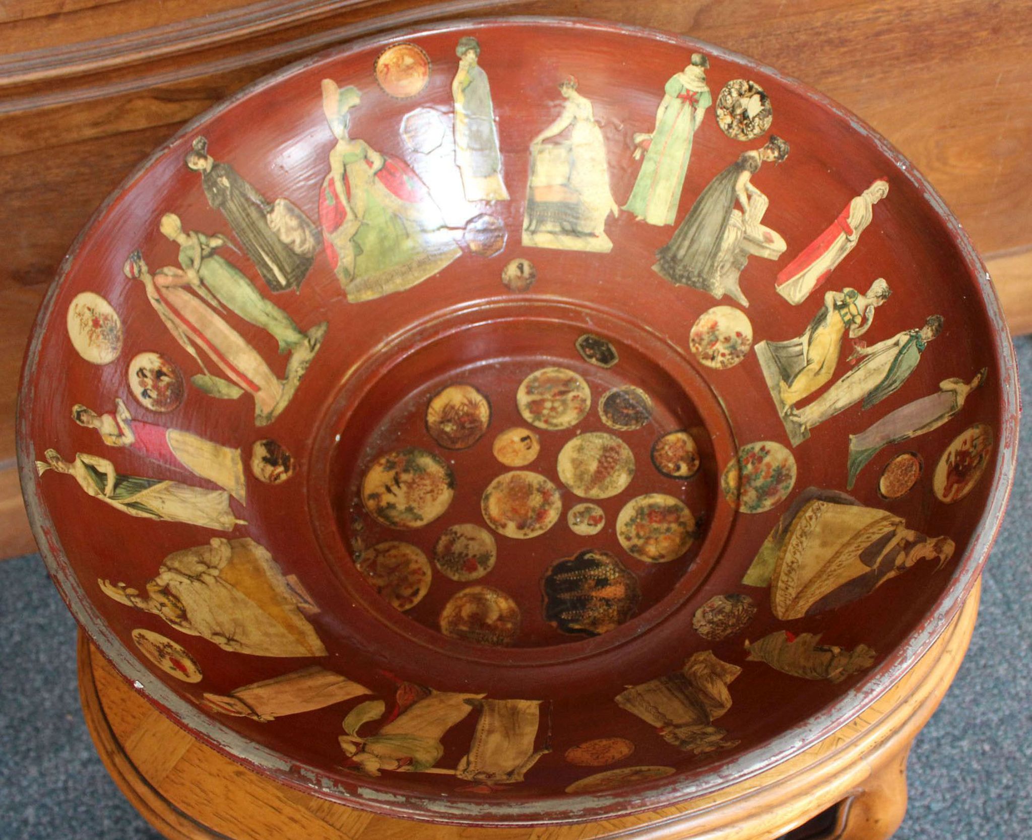 A large bowl with applied costume decoupage, 56.5cm dia x 21cm H.