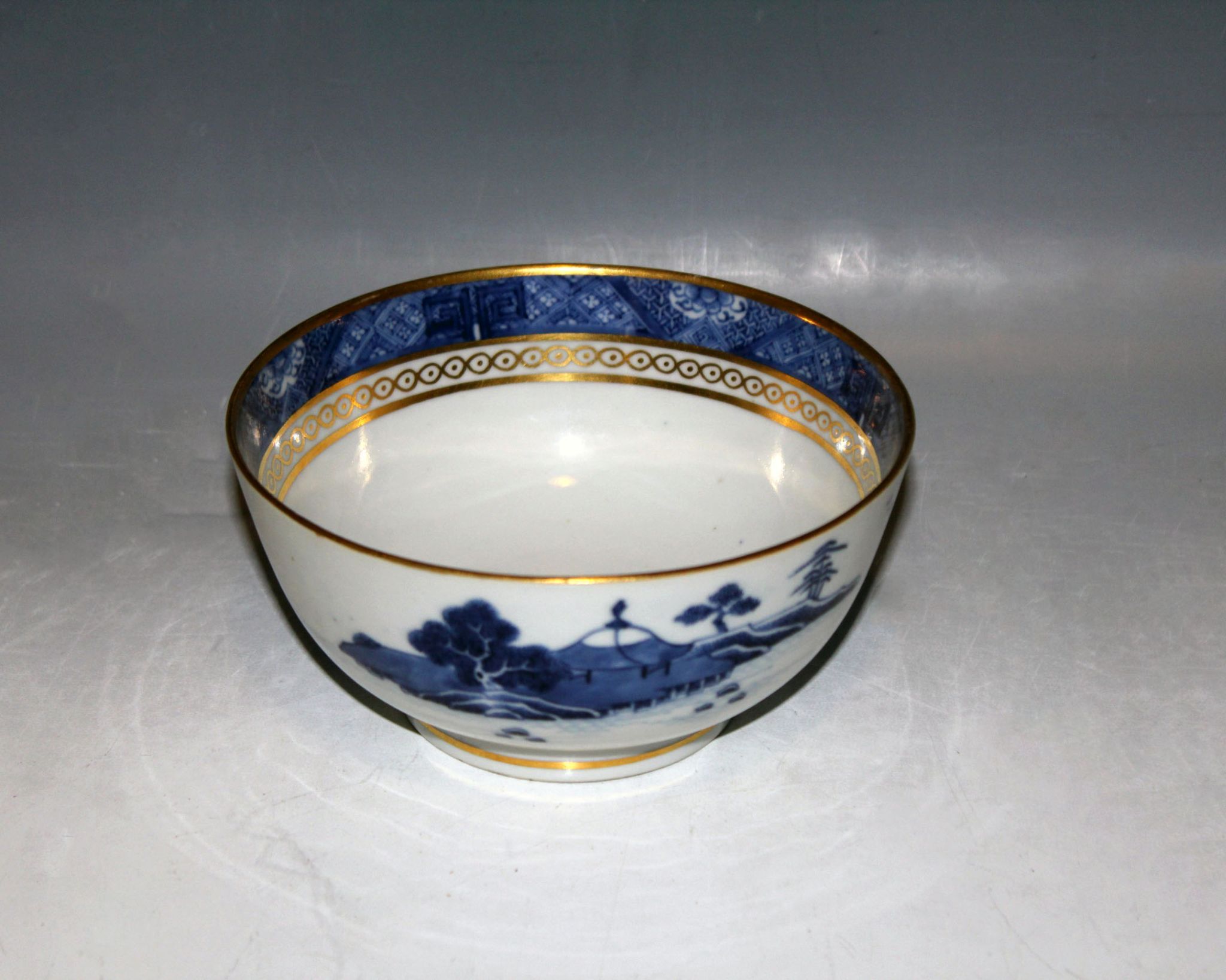 An 18th Century Chien Lung bowl, decorated with blue landscape, gilt embellishment to inner rim,