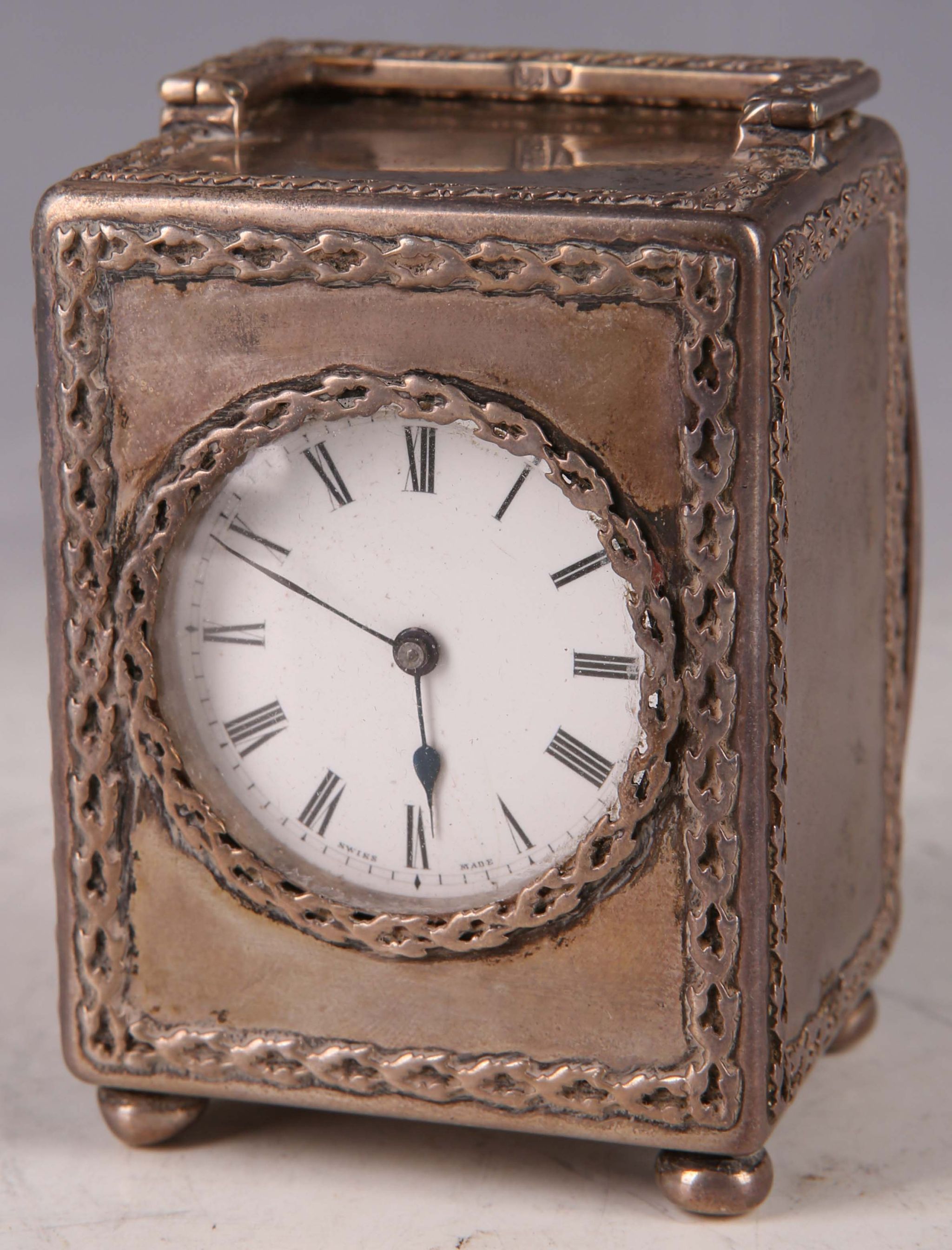 An Edwardian silver miniature travel clock, link decoration, enamel face with Roman numerals, 6.5cm,
