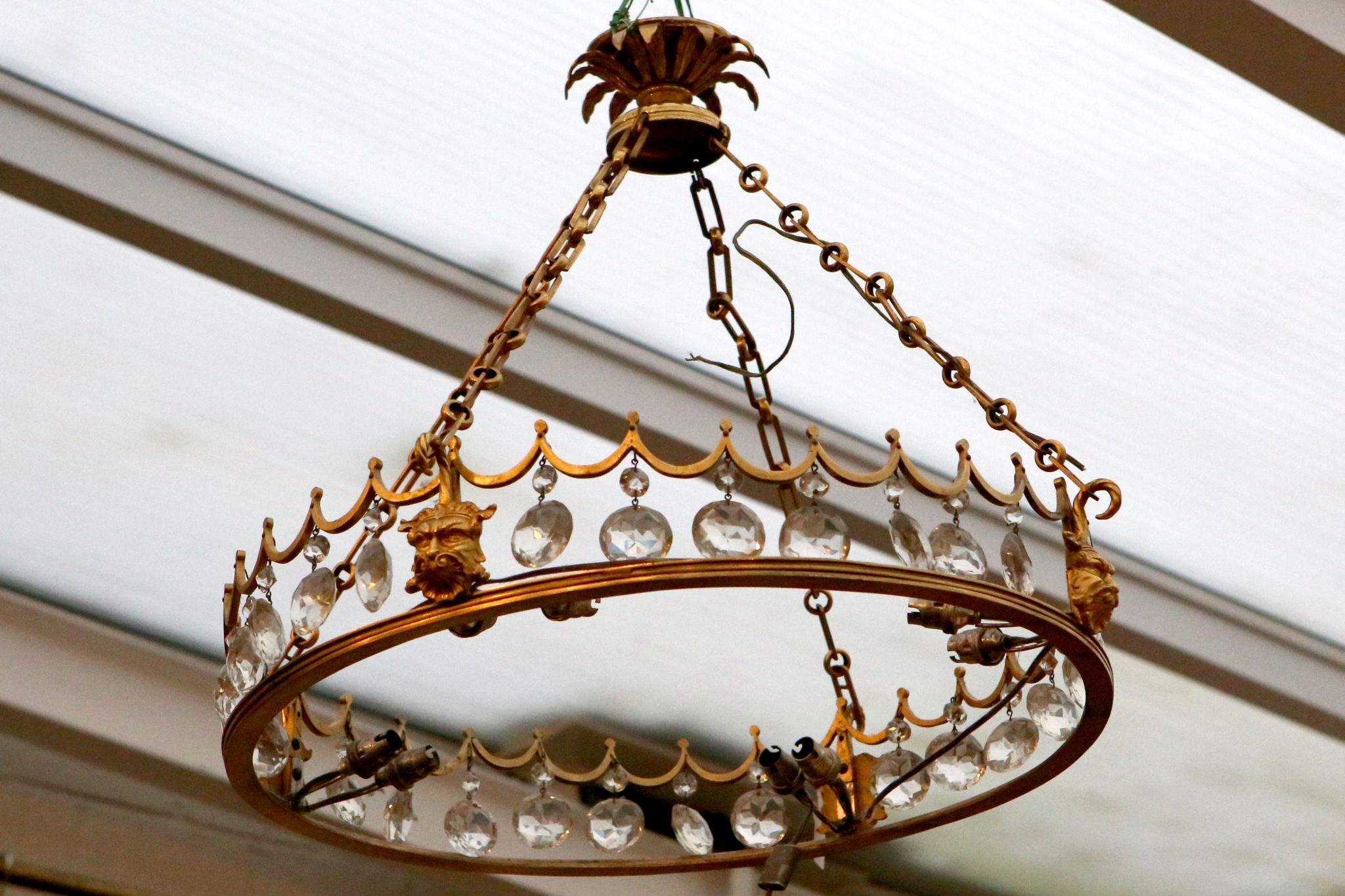 A Continental gilt bronze ceiling light frame, mask decoration, lustre drops, leaf ceiling mount,