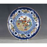 A Chinese plate, lobed rim, blue field, ladies in garden scene, four painted character marks to