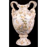 A 19th Century French faience vase, having baluster body with mask handles and supported on socle