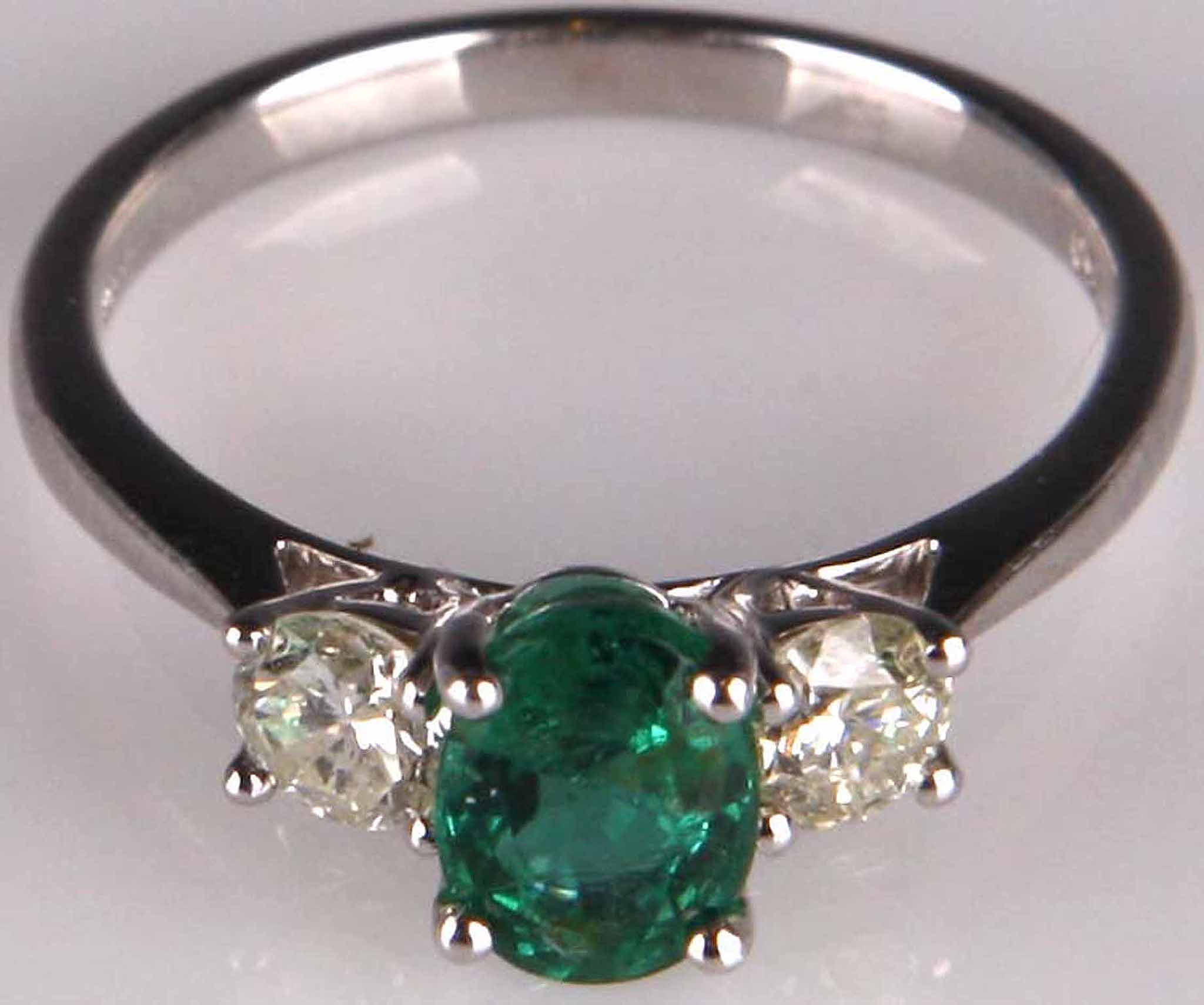 An 18ct white gold, emerald and diamond set ring (emerald 0.89ct, dia 0.52ct).