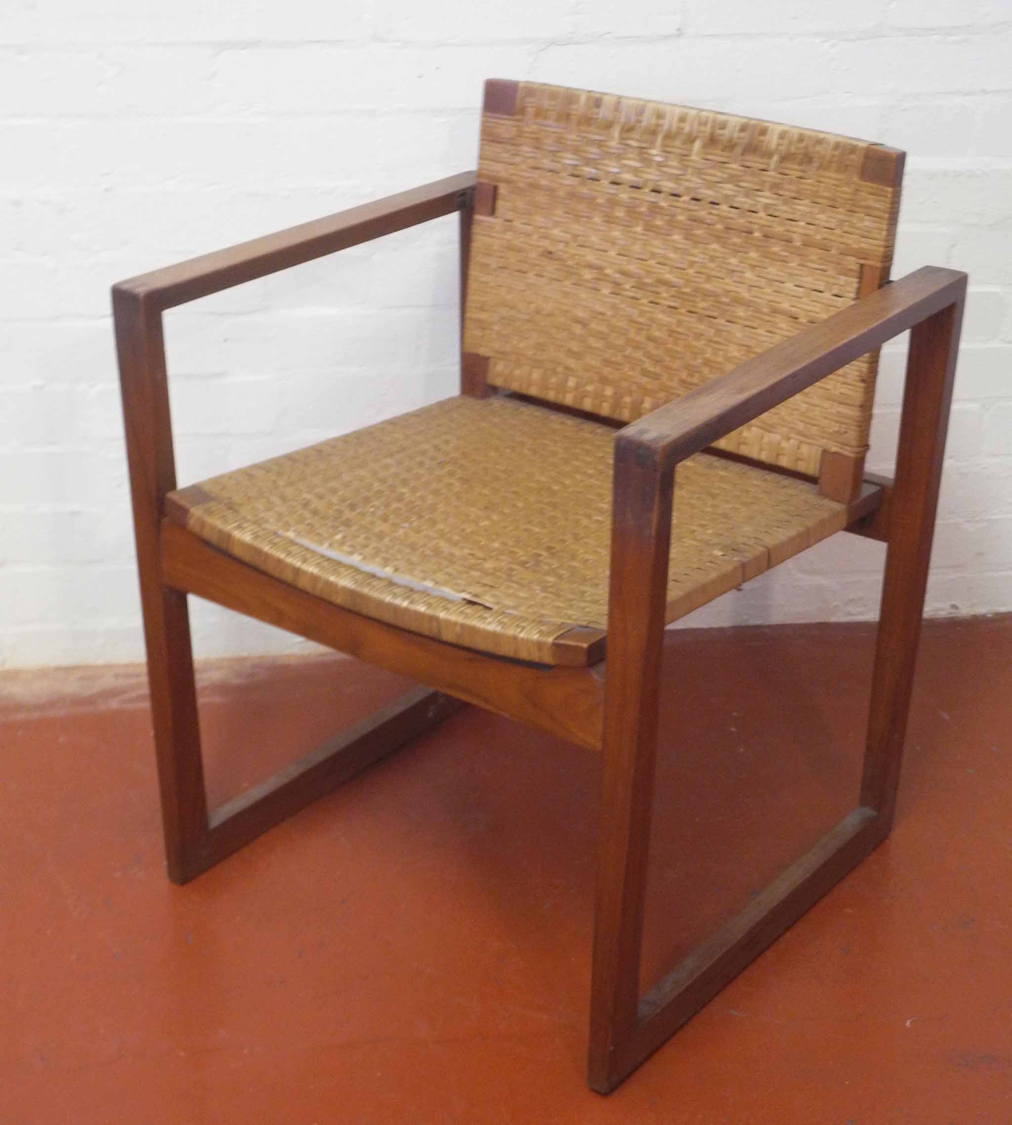 A 1960`s Danish teak armchair, a wicker seat and back rest on angular tapering frame.