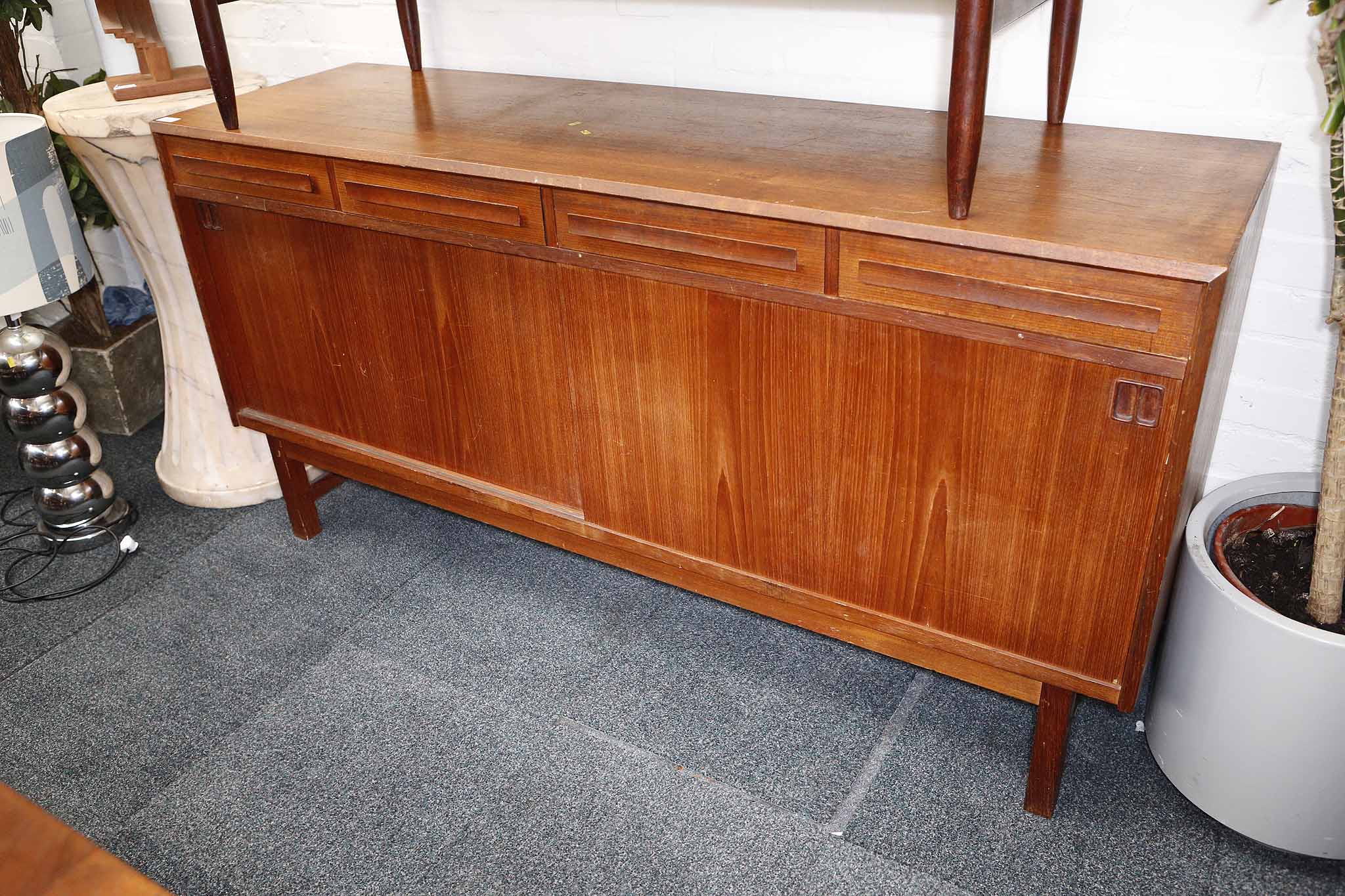 A 1960`s Danish teak sideboard, manufactured by Bordum and Nielsen, four frieze draws over double