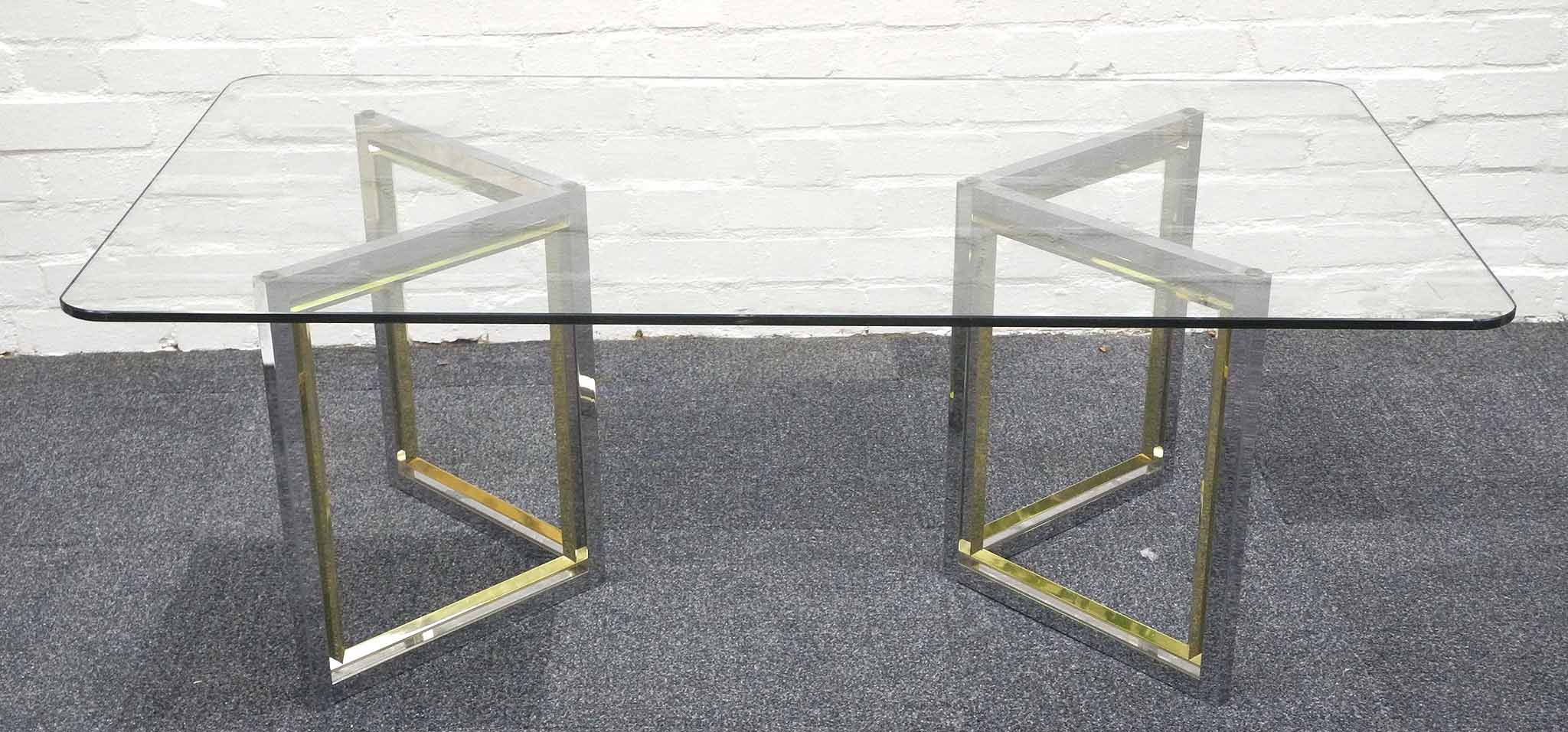 A 1970`s Italian coffee table, the glass top raised upon a pair of gilt metal and chrome supports.