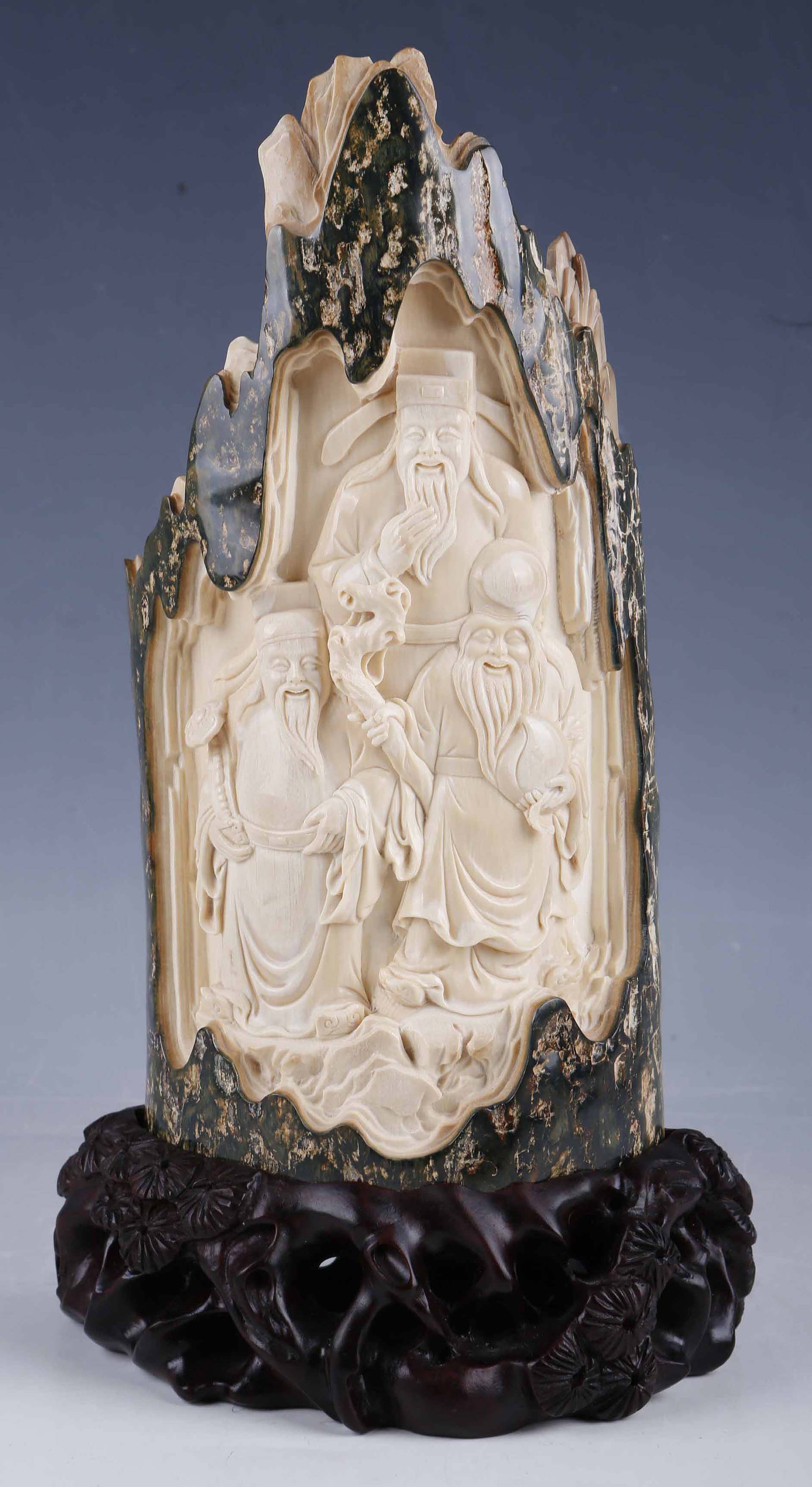 A Chinese 19th Century rock form ivory carving, green marble effect `frame` of three wise men, 20.
