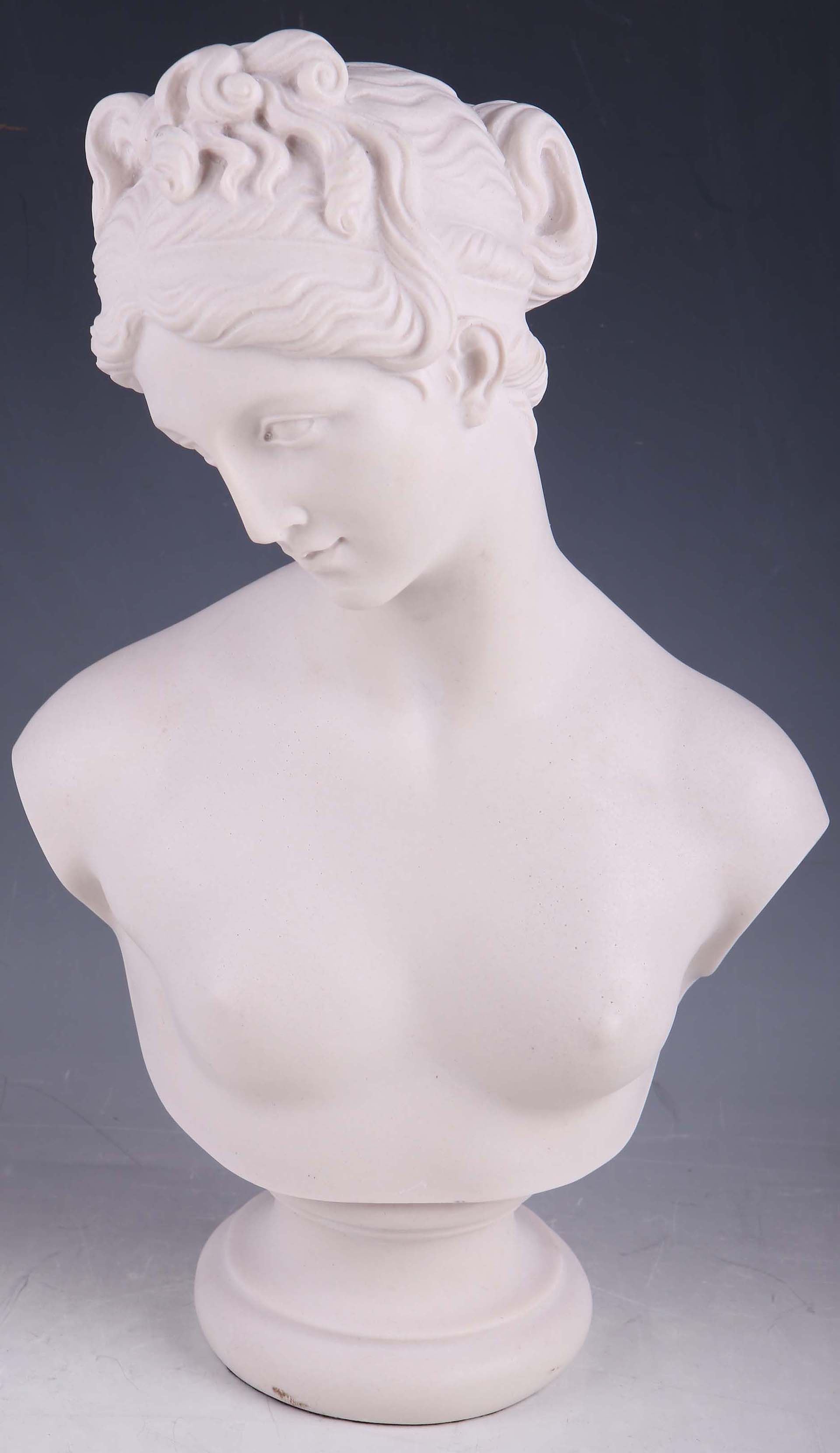 A faux marble bust of a Greek woman with braided hair, raised on a spreading socle base.