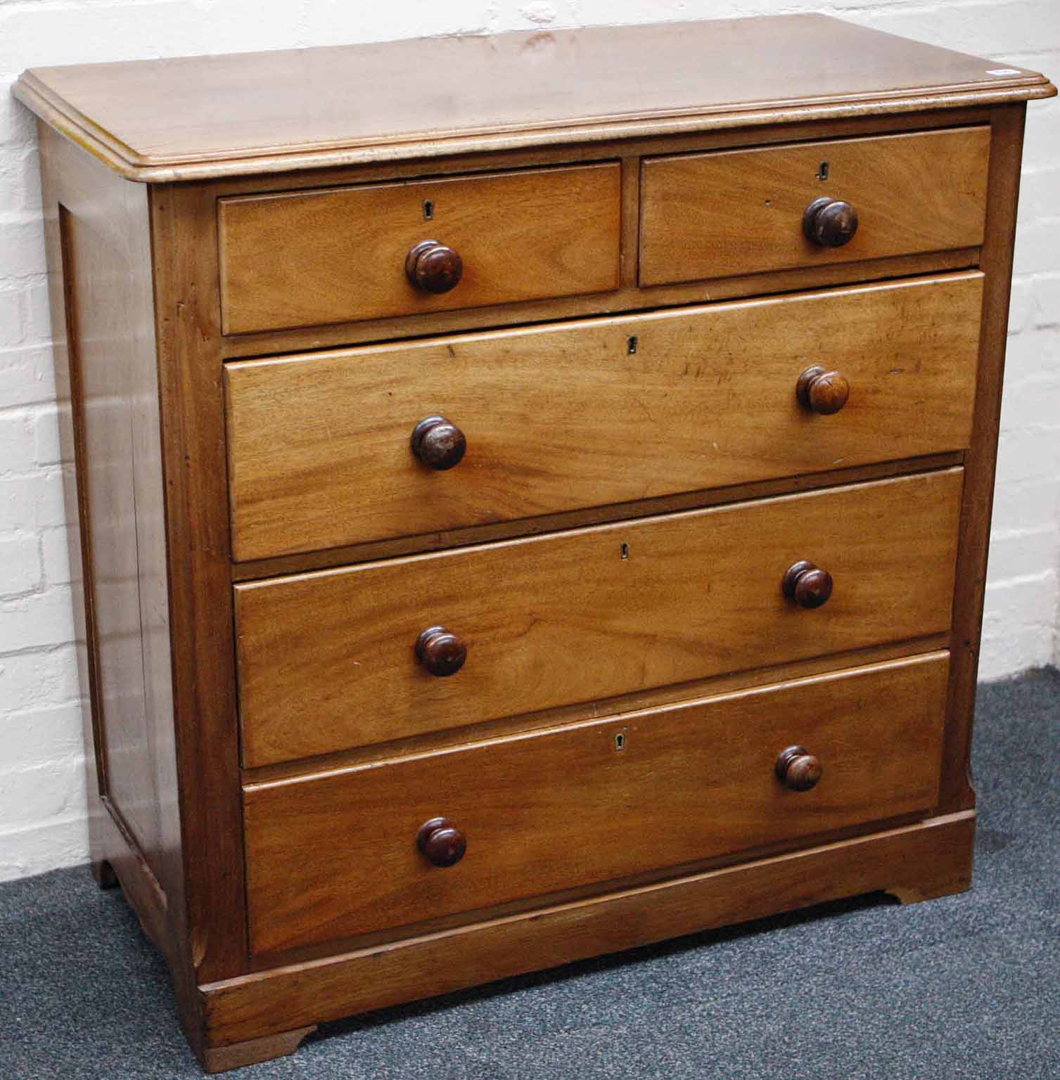 A late Victorian mahogany chest of drawers, having two short over three long drawers, panelled