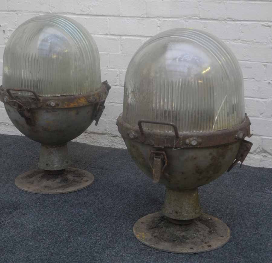 A pair of 1950s runway lights, with hinged dome glass lens tops upon steel case bottom and base. (2)