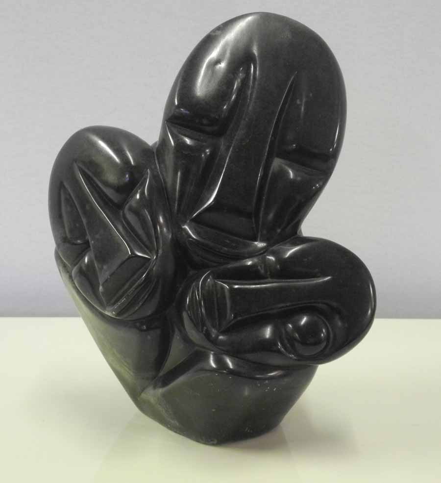 A modern Shona stone sculpture from Zimbabwe, Africa, a group of three faces, signed: Lawrence