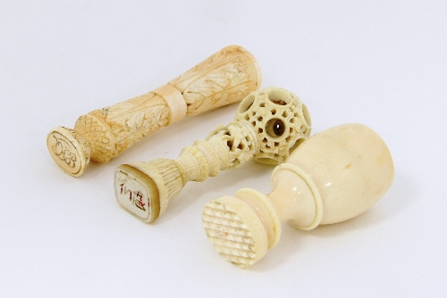 A Chinese ivory desk seal with puzzle ball handle, 6cm (2.25") long and two further ivory seals