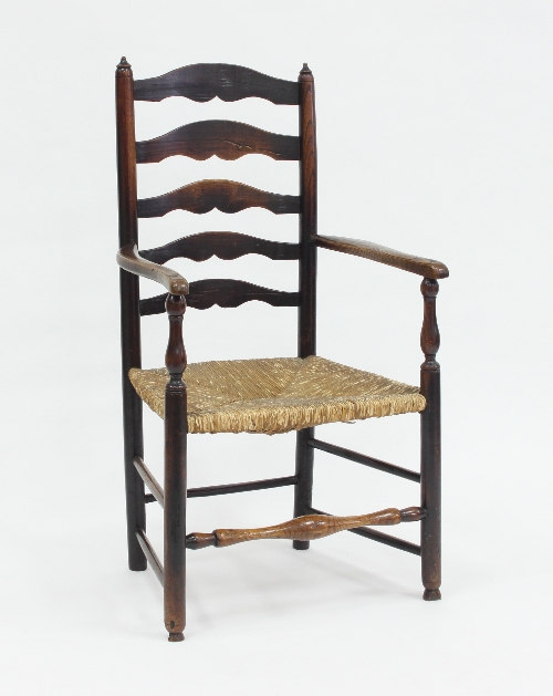 A rush seated ladder back armchair