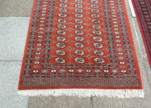 A Bokhara pattern runner, the central crimson ground field of eighty elephant foot medallions, 396cm - Image 3 of 5