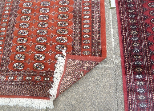 A Bokhara pattern runner, the central crimson ground field of eighty elephant foot medallions, 396cm - Image 4 of 5