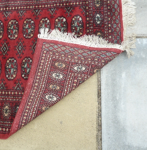 A Bokhara pattern runner, the central crimson ground field of eighty elephant foot medallions, 396cm - Image 5 of 5