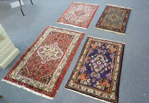 Three small Oriental rugs, 102cm (40"), 100cm (39") and 97cm (38") long, and another rug with