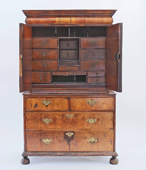 A Queen Anne walnut cabinet-on-chest, the bolection moulded drawer above two doors enclosing smaller