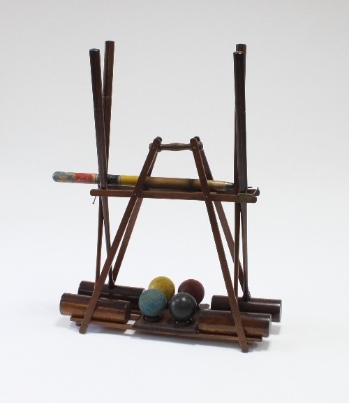 An ornamental croquet set, four mallets, four balls and a peg, in a carrying stand   Condition