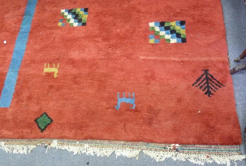 A modern Eastern carpet woven with geometric designs and camels on a tomato red ground 255cm x 198cm