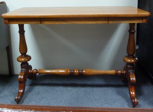 A Victorian mahogany centre table, the rectangular top on turned end supports and carved outswept