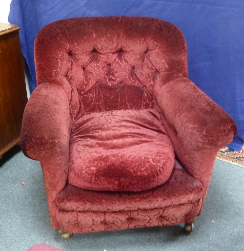 A Victorian upholstered armchair with deep button back on turned front legs