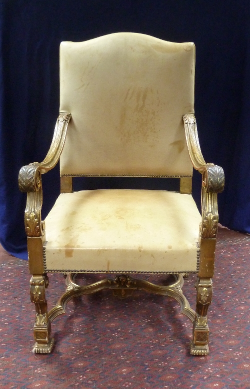 A 19th Century upholstered leather armchair, the parcel gilt moulded arms with acanthus
