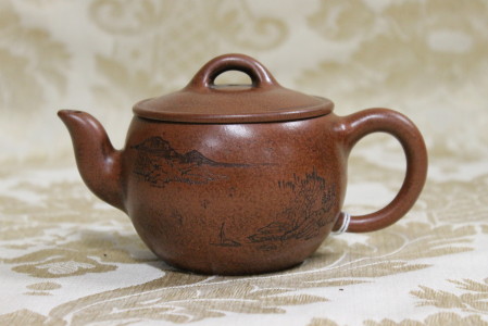 A fine Chinese terracotta tea pot with landscape decoration, signed to base. Height 9cm, Width 16cm